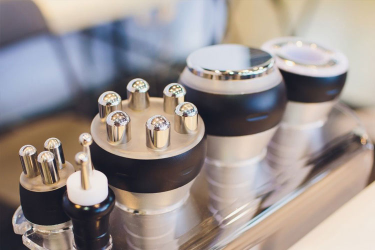Close-up of a tray holding multiple metal dental implant components with black bands and silver tops, organized for dental procedures