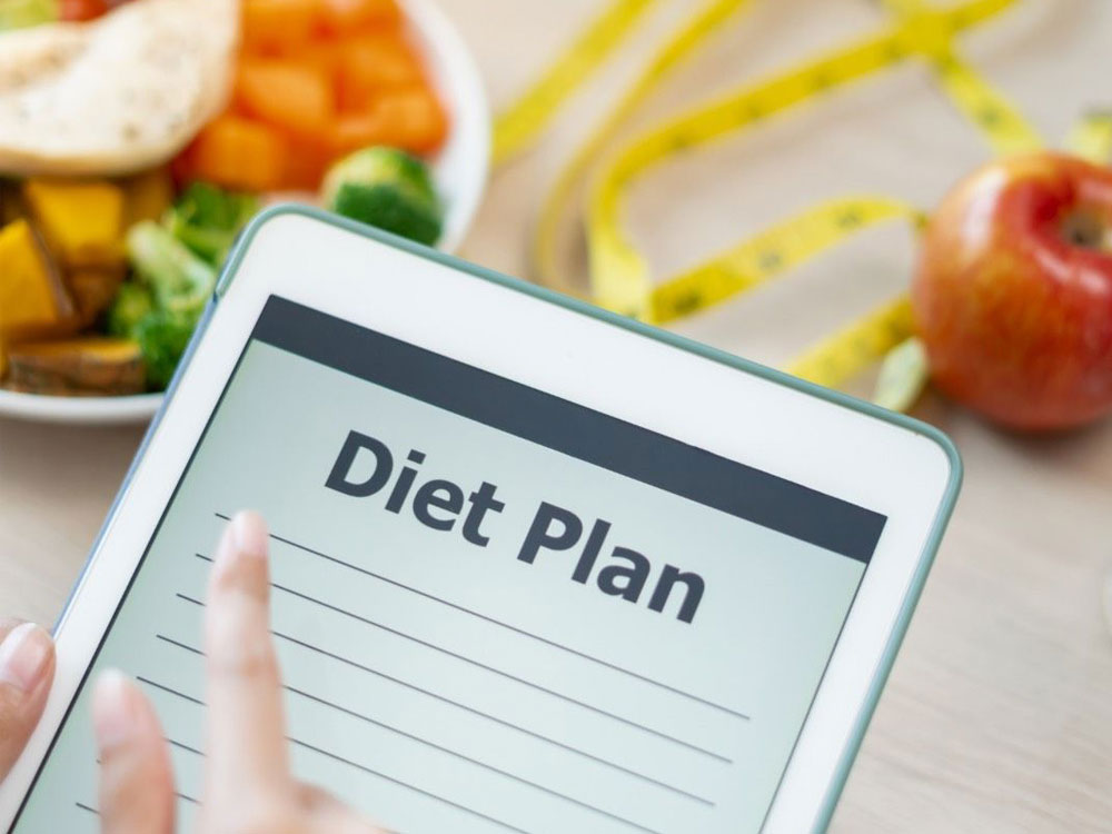 Tablet displaying 'Diet Plan' with a plate of vegetables and fruits in the background, suggesting meal planning.